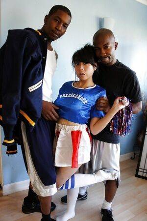 Awesome asian cheerleader May gets banged by these two black cocks on picsofsex.com