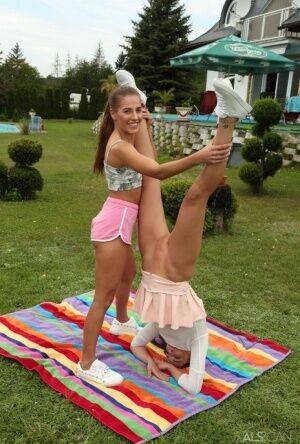 Young lesbians Eveline Dellai & Katy Rose fist pussies during sex on a lawn on picsofsex.com