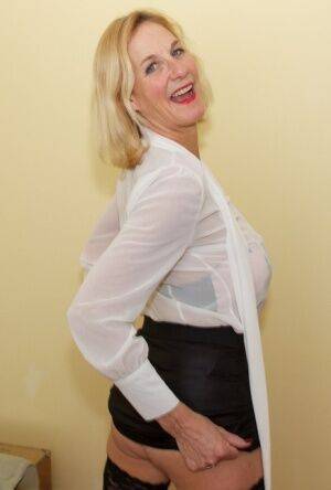 Mature blonde uncups big tits before tugging on labia lips after disrobing on picsofsex.com