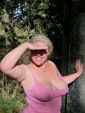 Thick blonde Barby bares her saggy boobs and bald cunt in a rural location on picsofsex.com