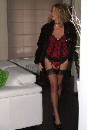 Blonde mature slut Kyra flaunting long legs in red lingerie & black stockings on picsofsex.com