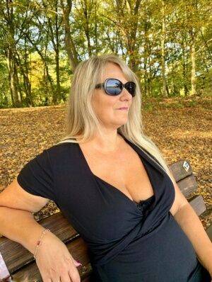 Older blonde Sweet Susi hikes up a black dress to expose her snatch in nature on picsofsex.com