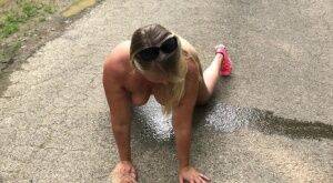 Blonde amateur Sweet Susi takes a piss while naked on a paved road on picsofsex.com