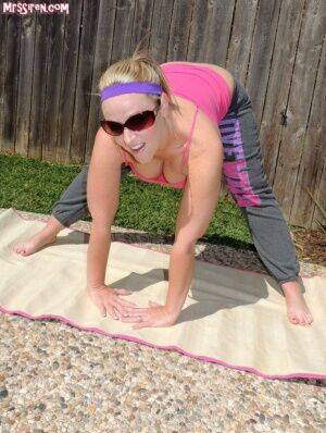 Blonde chick Dee Siren frees her huge ass from yoga pants outdoors on yoga mat on picsofsex.com