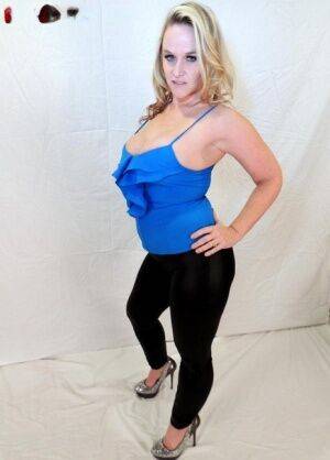 Blonde amateur Dee Siren shows her ample cleavage in black leggings on picsofsex.com