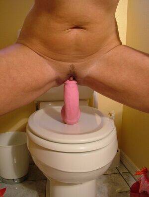 Older amateur Dee Delmar rides her pink dildo on top of toilet seat on picsofsex.com