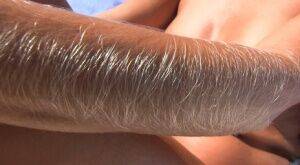 MILF Lori Anderson naked on the beach to show off her long arm hair in the sun on picsofsex.com