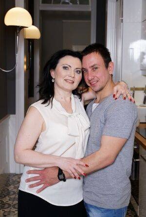 Horny older woman fools around with her boy toy during foreplay on sofa on picsofsex.com