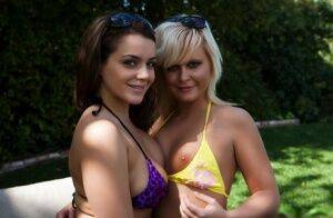 Lesbian girls Natasha and Kelly release their tits from bikini tops in a yard on picsofsex.com