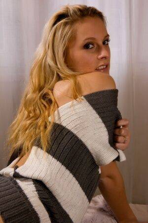 Blonde chick Joe shows her bald pussy in a sweater and black boots on picsofsex.com