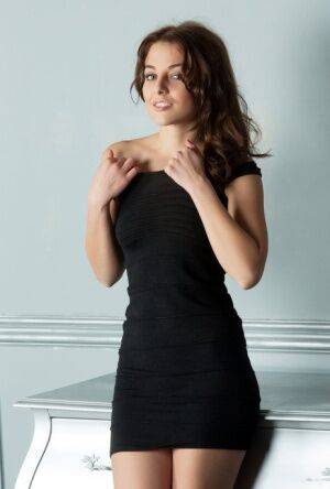 Hot brunette Nikia peels off her tight dress to spread showing bald pussy on picsofsex.com