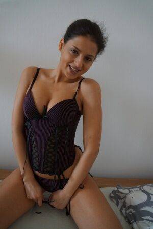 Amateur girl Coco Del Mal goes topless on her bed before sliding a thong aside on picsofsex.com