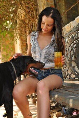 Solo girl Kayleigh Williams enjoys a cool drink while walking nude on sidewalk on picsofsex.com