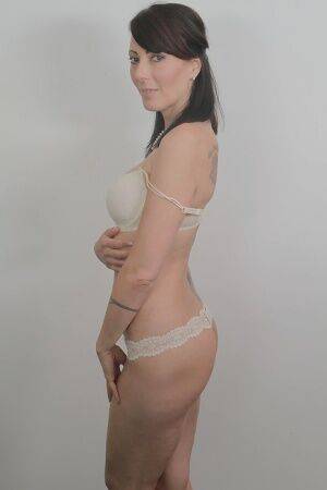 Tattooed milf Zoe Holloway showing off in a white lingerie and panties on picsofsex.com