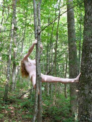 Natural redhead Nicki Blue swings from a tree while totally naked in the woods on picsofsex.com