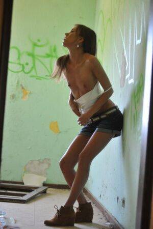 Thin female pours water over her naked twat in a derelict building on picsofsex.com
