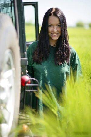 Dark haired girl Gwen A strips naked on top of a Land Rover on safari on picsofsex.com