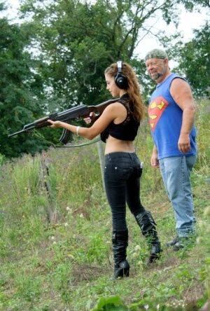 Latina teenager Gigi Rivera goes topless while firing off a rifle in woods on picsofsex.com