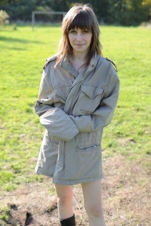 Teen exhibitionist Lena removes a coat before flashing on a soccer field on picsofsex.com