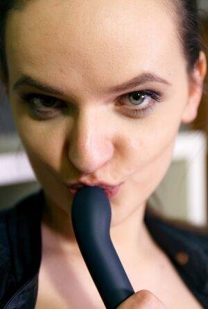 Brunette teen in a lather jacket and stockings toys her bald vagina on picsofsex.com