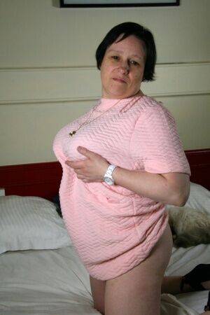 Fat older woman undresses on her bed before toying her pussy on a bed on picsofsex.com