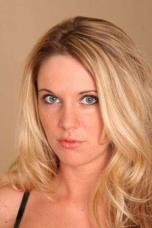 Blonde amateur A J Bailey undoes her bra to model naked on top of her bed on picsofsex.com