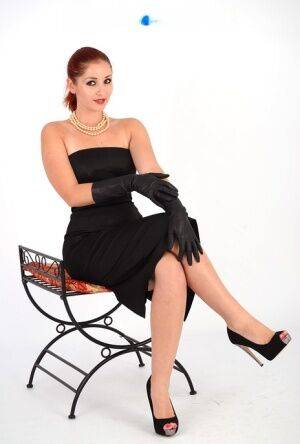Natural redhead Harley looses firm tits from a black dress in leather gloves on picsofsex.com
