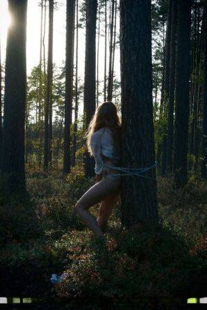 Handcuffed teen Kristine masturbates while being chained to a tree in woods on picsofsex.com