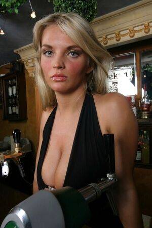 Blonde chick Ines Cudna exposes a large breast while tending bar on picsofsex.com