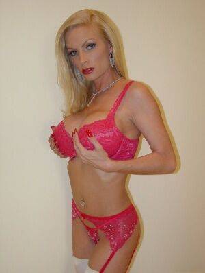 Older blonde babe Diamond Foxxx toys her twat on a bed in white stockings on picsofsex.com