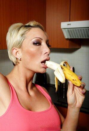 Tight pornstar Pearl Diamond eating a banana and posing naked in a kitchen on picsofsex.com