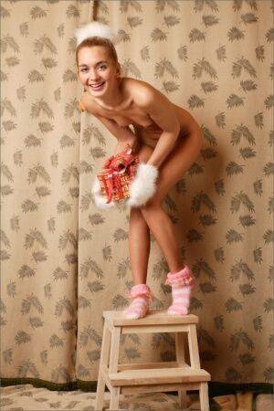 Blonde girl Sweet Lilya wears furry gloves and socks during a nude solo shoot on picsofsex.com