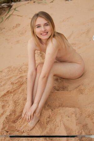 Cute teen girl Lia Kate gets totally naked on a sandy beach on picsofsex.com