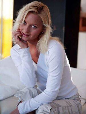 Blue-eyed blonde gets completely naked on a sofa during solo action on picsofsex.com