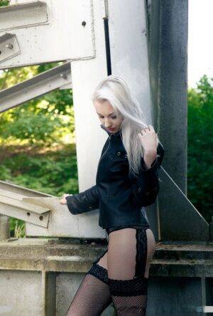 European teen Adelina White takes a pee on trestle bridge in black stockings on picsofsex.com