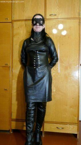 Collared solo woman models leather clothing while wearing a mask on picsofsex.com