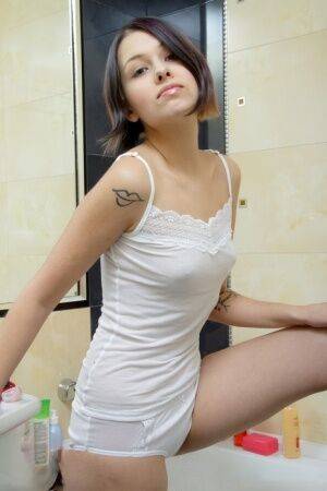 Young looking teen Maxine masturbates while covered in soap bubbles in a tub on picsofsex.com