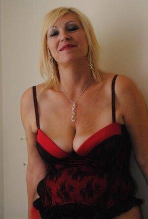 Older amateur Platinum Blonde models hot lingerie and hosiery on a bed on picsofsex.com