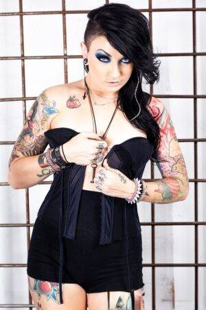 Tattooed girl Draven Star gets naked in heels inside a steel cage on picsofsex.com