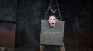 Blonde girl Odette Delacroix is made to suck a black cock with head in stocks on picsofsex.com