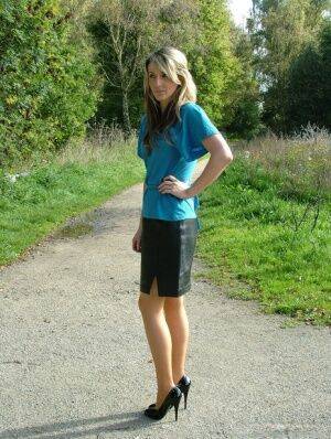 Clothed woman shows off her shapely legs outdoors in a skirt and black pumps on picsofsex.com