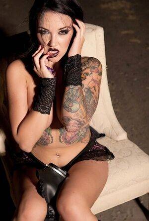 Tattooed girl Emily Parker takes off a gas mask and black bra outside at night on picsofsex.com