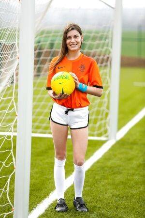 Lilly P is undressing her soccer uniform while on the field with a ball on picsofsex.com