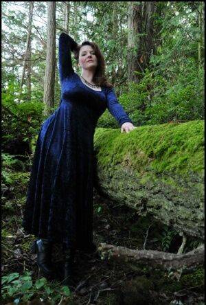 Mature woman Tasty Trixie heads into the woods to flash in a long velvet dress on picsofsex.com