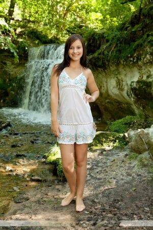 Solo girl Rosalin E removes lingerie to model naked in front of a waterfall on picsofsex.com