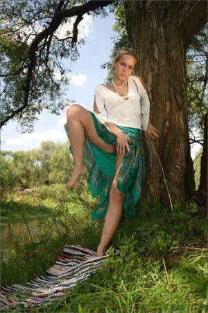 White teen frees her thin body from clothes next to a still river on picsofsex.com