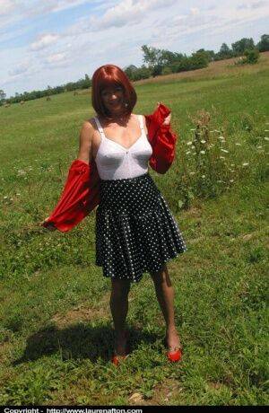 Older redhead Lauren models a retro girdle and nylons in a field on picsofsex.com