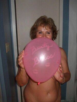 Mature lady models totally naked while playing with balloons on picsofsex.com