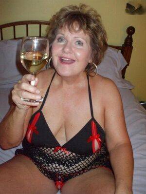 Older woman Busty Bliss licks her toy boy's dick over a glass of wine on picsofsex.com