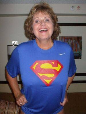 Older amateur Busty Bliss looses her big tits from a Superman T-shirt on picsofsex.com